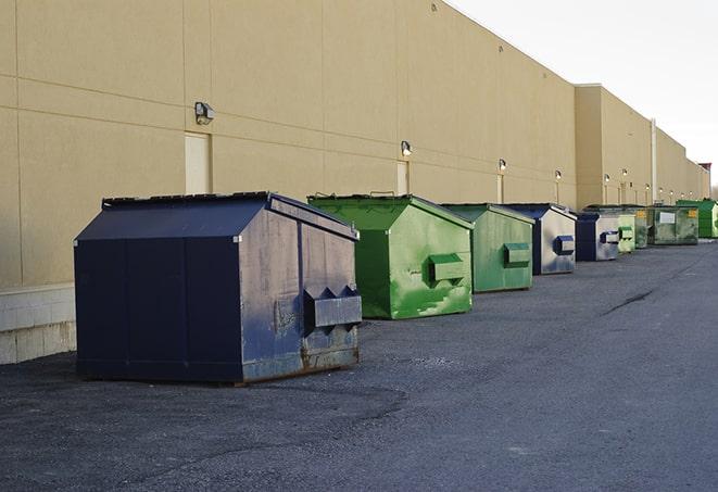 construction workers toss wood scraps into a dumpster in Appleton